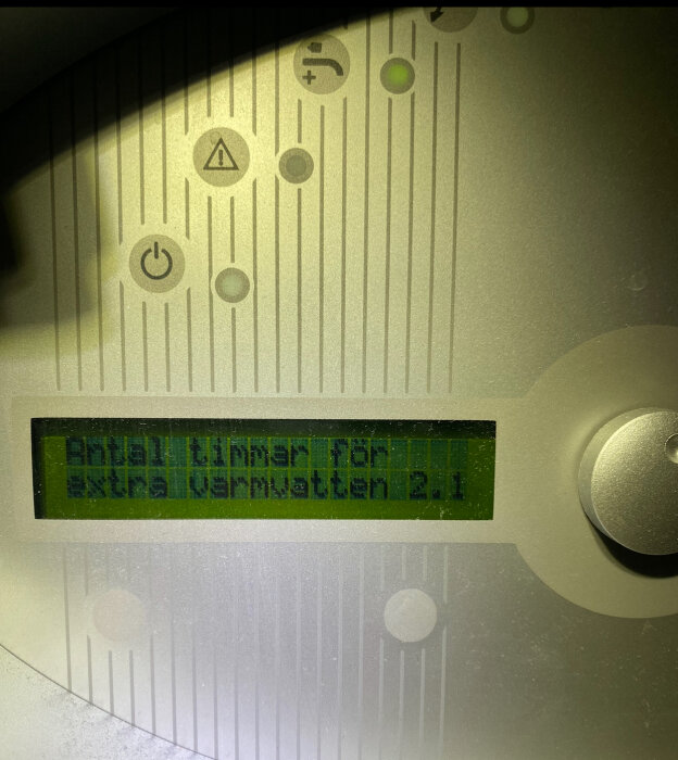 Displaypanel för IVT värmepump med texten "Antal timmar för Extra varmvatten 2.1" synlig på skärmen.