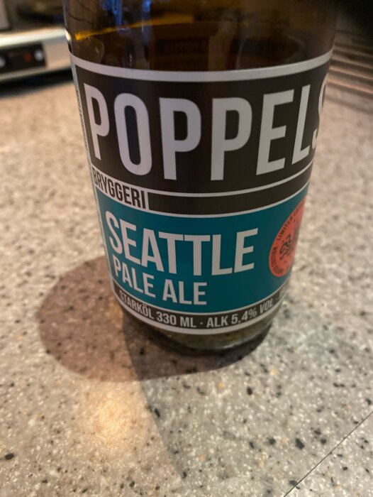 Flaska av Poppels Bryggeri Seattle Pale Ale på köksbänk.