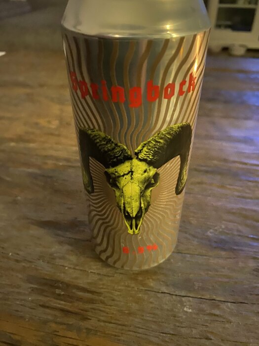 Ölburk med bockmotiv på ett träbord, märkt "Springbock", 6,5% alkoholhalt.