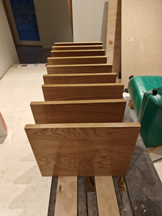 Waxade trähyllor i olika storlekar ordnade i en trappa på en byggbänk.