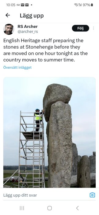 Personal på ställning vid stenblock i Stonehenge för justering inför sommartid.