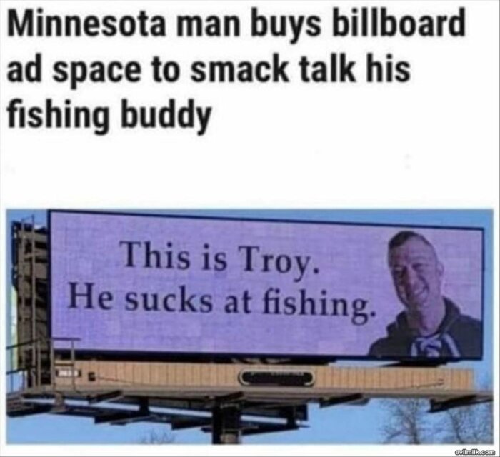 Reklamskylt med texten "This is Troy. He sucks at fishing" och en man som ler.