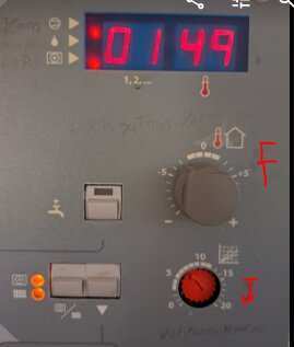 Panel av värmesystem med digital display som visar 01:49, inställd värmekurva J på 8, och förskjutningsvärmekurva F på -3.