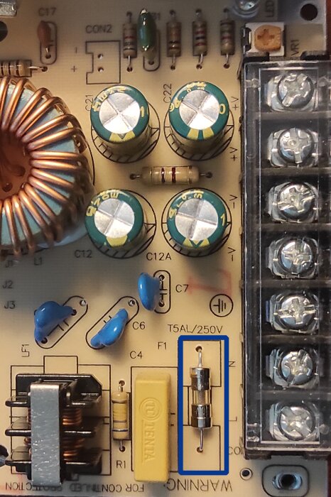 Kretskort med komponenter och markerad glassäkring T5AL/250V.