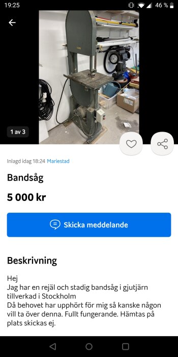 Vertikal bandsåg i ett garage med arbetsbänk och diverse verktyg i bakgrunden.