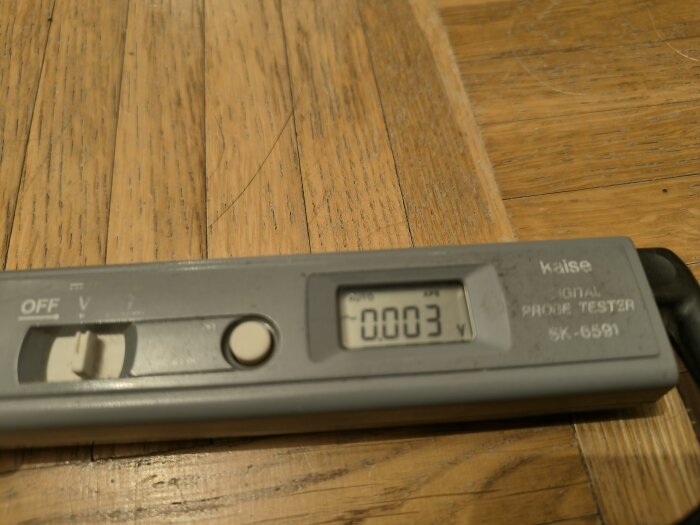 En använd multimeter på ett träbord, digital display visar "-0003", märkt med "Kaise Sk-6581".