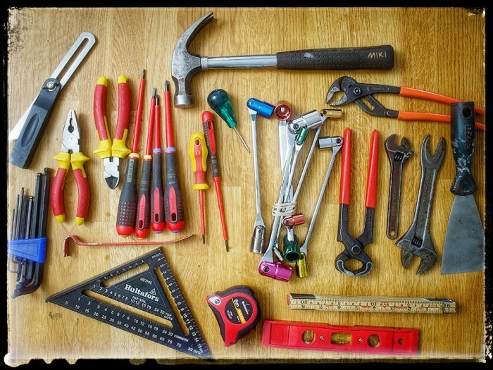 Samling verktyg för bygg- och renoveringsprojekt, inkluderar hammare, skruvmejslar, tänger och måttverktyg.