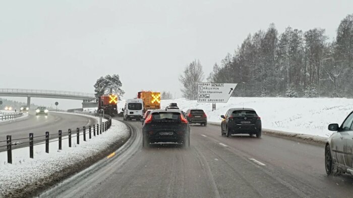 Snöiga vägförhållanden med bilar i kö bakom vägsaltare på en Europaväg.