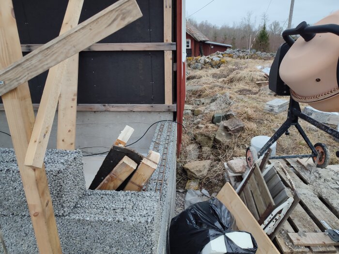 Byggarbetsplats med lecablock vid trävägg, med fråga om tätning och fuktskydd vid skarvningen.