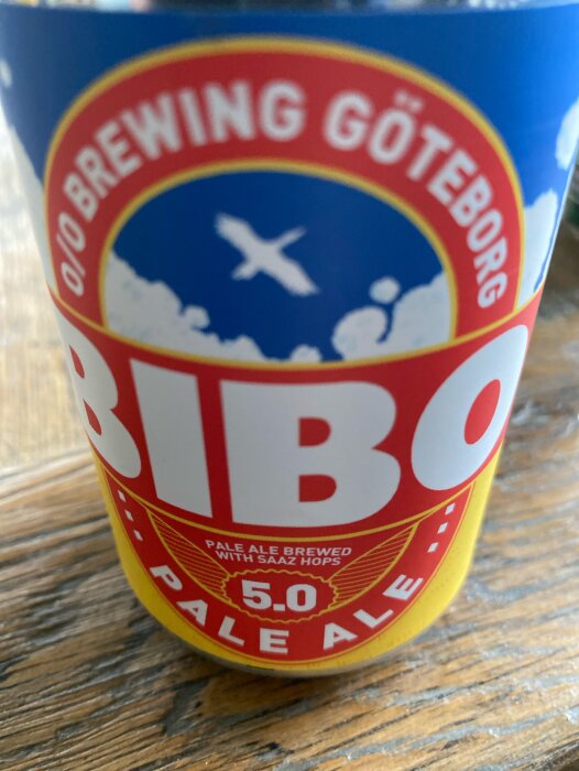 En ölburk med texten "BIBO BREWING GÖTEBORG PALE ALE" på träbord.