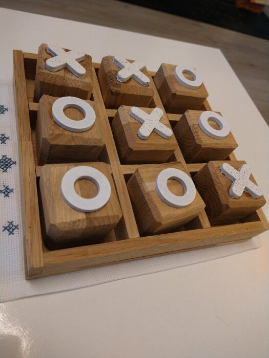 Ett hemgjort Tic-Tac-Toe (Tre-i-rad) spel med bitar och spelbräde av stavlimmad ekbänkskiva.