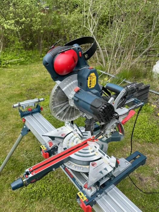 Bosch Professional GCM 8 SJL kap & gersåg och GTA 3800 sågbord mot en grönskande bakgrund.