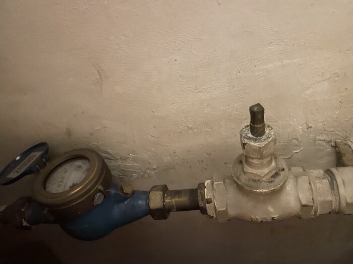 Vattenmätare och avstängningsventil utan vred för huvudvattenledning i ett hus.