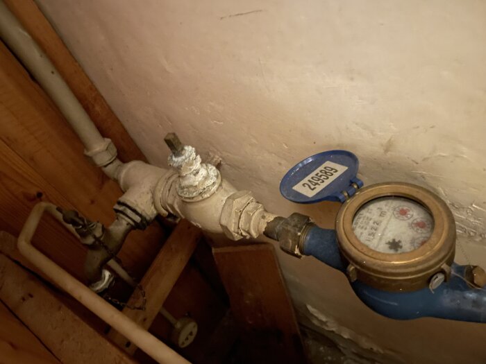 Vattenmätare och huvudvattenledning i ett hus utan synligt avstängningsvred.