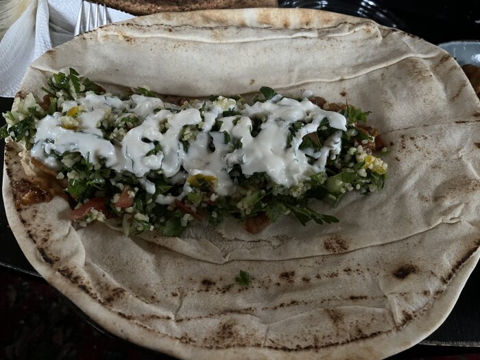 Öppen libabrödwrap med kyckling, tabbouleh, vitlökssås och en hint av hotsås.