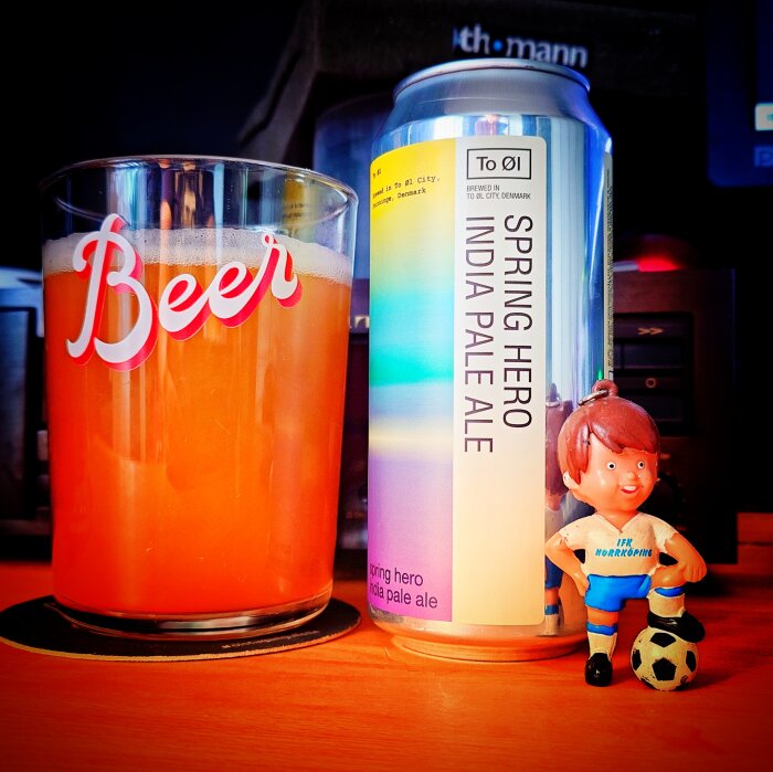 Ett glas öl med texten "Beer", en burk India Pale Ale och en fotbollsfigur i blått och vitt.