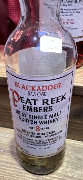 Närbild av en öppnad whiskyflaska av märket Blackadder, Peat Reek Embers, en Islay Single Malt Scotch Whisky, åldrad i 8 år.