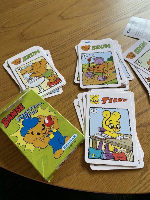 Spelkort med serietillvärn "Bamse" på ett bord, inklusive kort med figurer "Brum" och "Teddy".