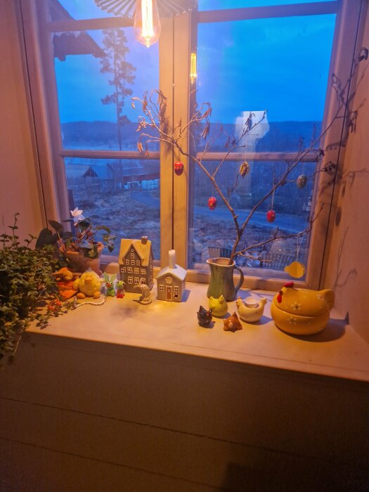 Ett hemtrevligt fönsterbänk med dekorativa föremål och utsikt över ett landskap vid skymningen.