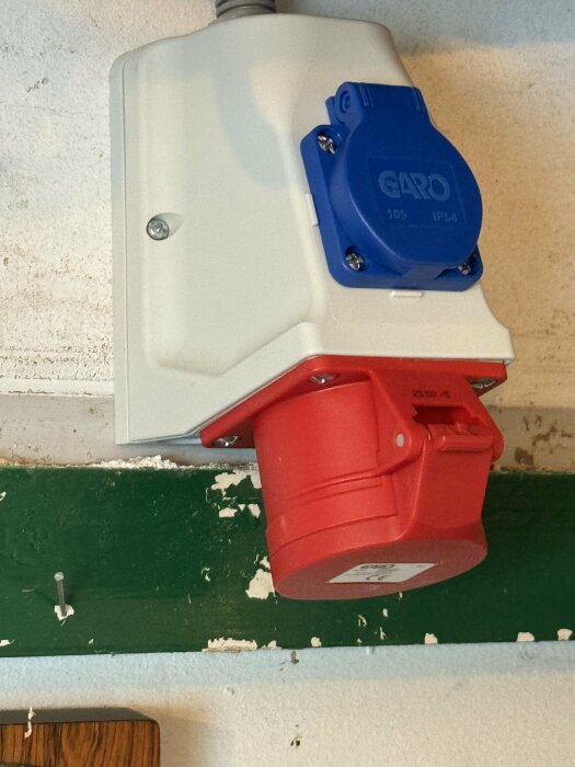 CEE-uttag monterat på vägg, ett blått och ett rött, för industriell användning.