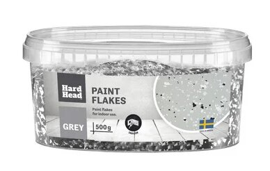 Plastburk med etikett 'Hard Head PAINT FLAKES' fylld med gråa målarfjäll, används för inomhusmålning.