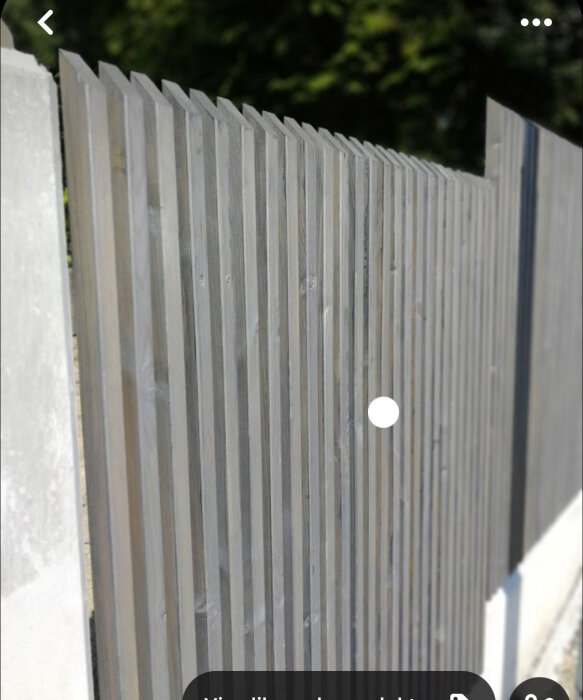 Staket av gråa vertikala ribbor med synlig fästdetalj för ökat insynsskydd.