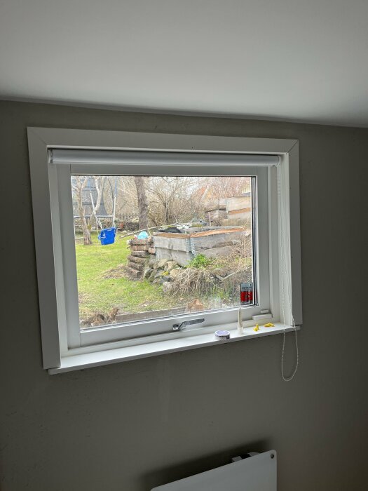 Nyinstallerat fönster i sovrum med utsikt över trädgården.