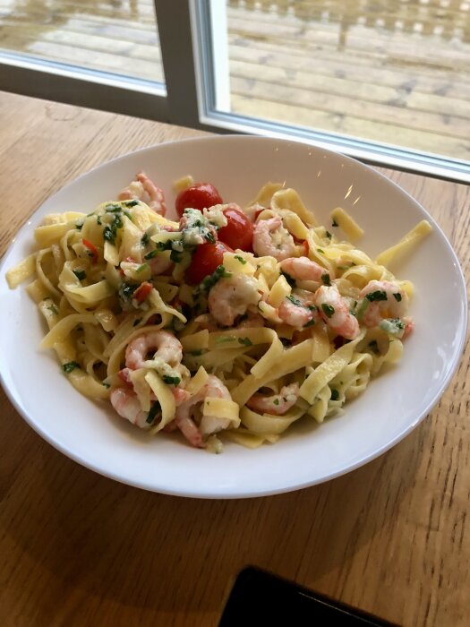 Tallrik med pasta, räkor, körsbärstomater och rikligt med parmesan.