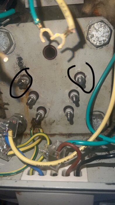 Elektrisk kopplingspanel med utvalda komponenter ringade, kopplingstrådar och säkringar.