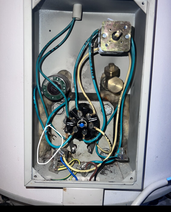 Öppet elskåp med elpatron, ledningar och termostat, en kabel löst hängande till vänster.