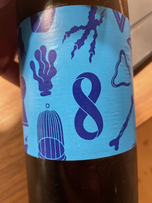 Närbild av en dryckesetikett från Omnipollo Levon med abstrakta mönster och symboler, blå nyanser.