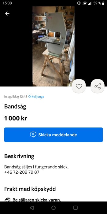 En vit bordsbandsåg av märket INCA står på en pall i ett verkstadsrum.