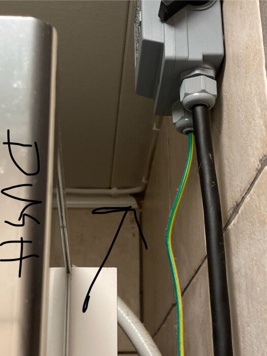 Oorganiserad eldragning i ett badrum med synliga kablar och en apparatdos.