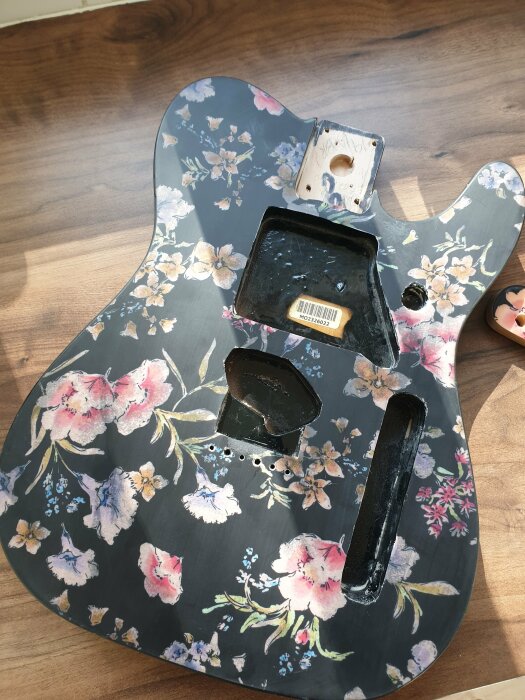 Fender Telecaster gitarrkropp med blommigt mönster limmat på fram- och baksida, redo för lackering.