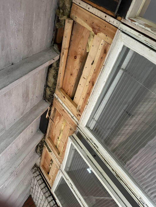 Bild på öppet fönsterparti med synlig träkonstruktion och isolering i ett hus under renovering.
