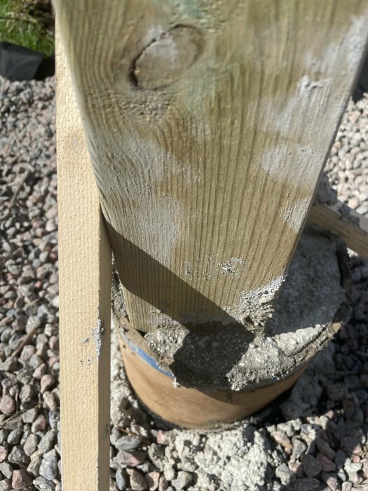 Grovregel står ovanpå betongplint där betong saknas runt gjutröret och en bräda är nära kanten utan stöd.