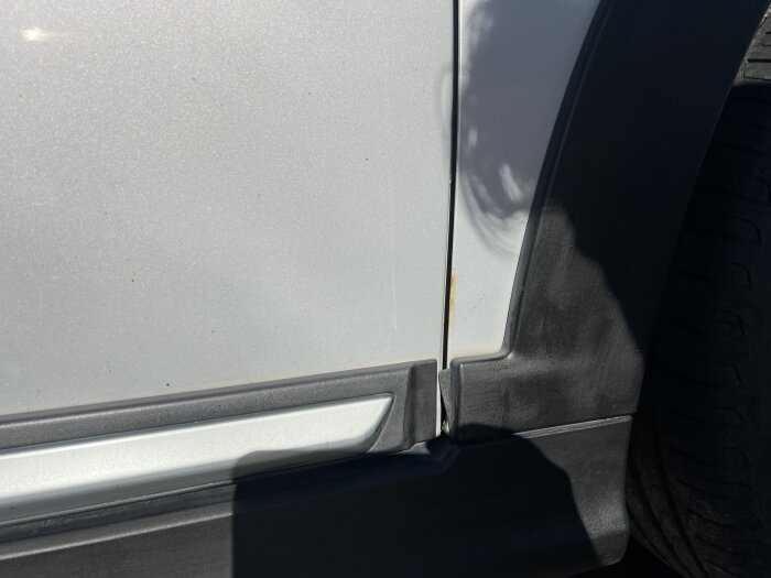 Bilens sidpanel närbild med flygrost och smuts kvar efter tvätt.