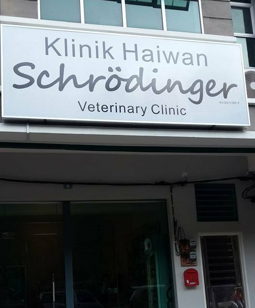 Skylt för "Klinik Haiwan Schrödinger Veterinary Clinic" på en byggnadsfasad.