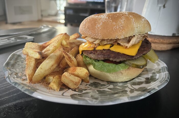 Hamburgare med ost och specialcoleslaw toppad med rostad lök, serverad med en sida kryddiga pommes på tallrik.