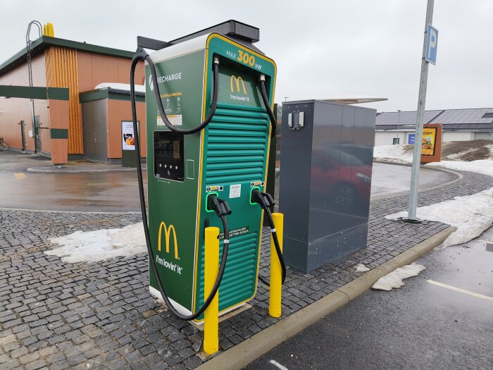 Elektrisk laddstation för fordon med McDonald's logotyp och parkeringsplats, belägen i norra Sverige/Finland.