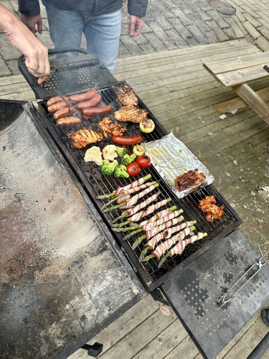 Grill fylld med mat såsom korvar, kyckling, grönsaker och sparris insvept i bacon under en informell lunch på jobbet.