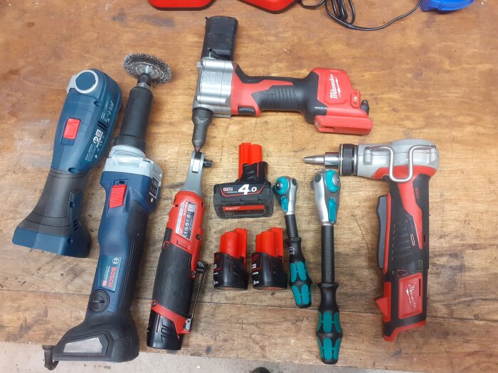 Samling av nya verktyg på ett arbetsbänk, inklusive borr, skruvdragare och bits.