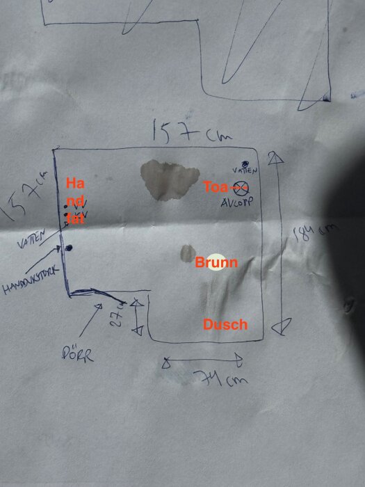 Handritad skiss av badrumsplanering med markerade positioner för handfat, toalett och dusch.
