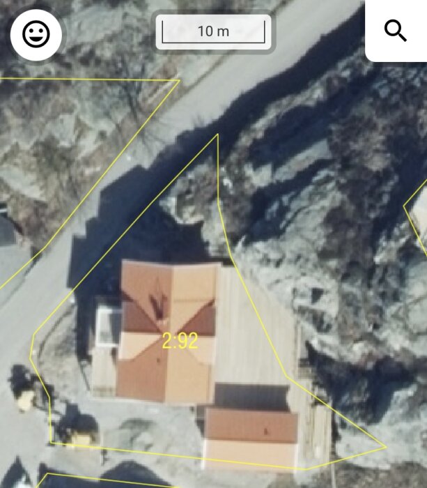 Flygbild av tomt med markerad gräns och befintligt hus, indikerar problem med avstånd till tomtgräns.