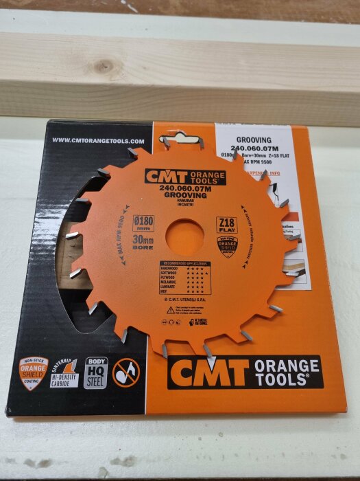 CMT Orange verktygsklinga i förpackning på träbänk, för bygg- och renoveringsarbete.