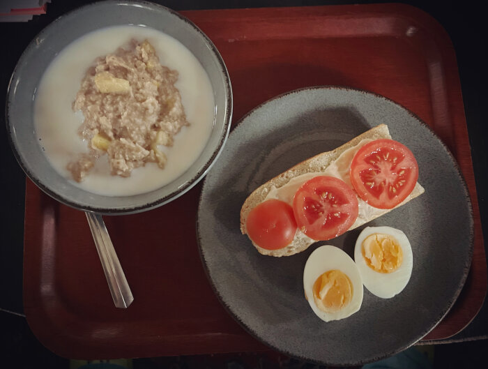 Havregrynsgröt med äpple och kanel, macka med tomat, halverat kokt ägg på bricka.