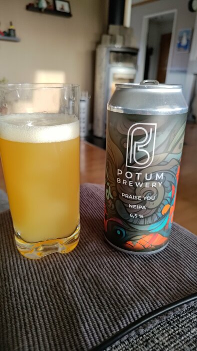 En öppnad burk Potum Brewery NEIPA öl och ett glas med öl på ett bord.