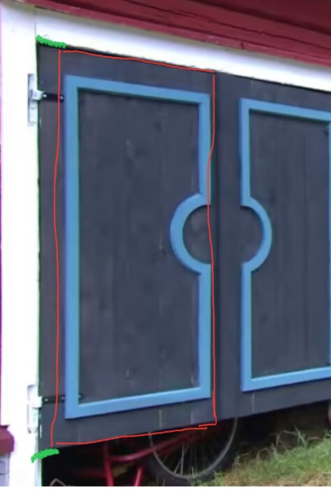 En grå dubbeldörr med dekorativa ljusblåa detaljer monterad på en byggnad, utan synlig plastlist på utsidan.