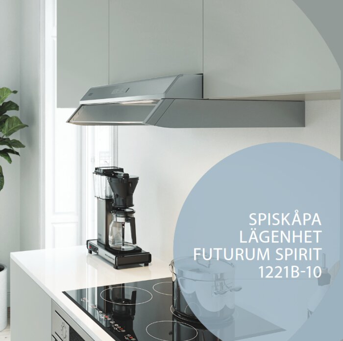 Franke Spirit spiskåpa installerad under vita köksskåp ovanför en svart häll och bredvid en kaffebryggare.