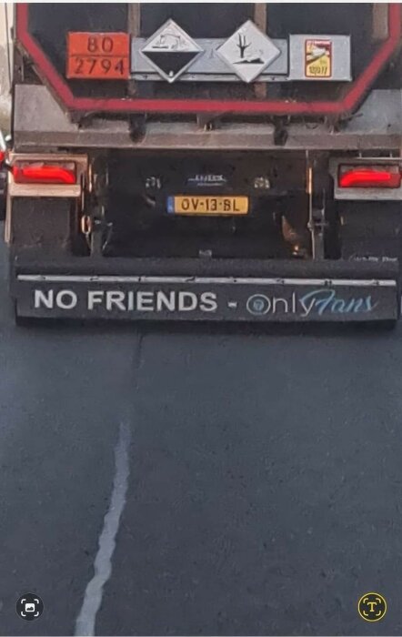 Bakre delen av en lastbil med texten "NO FRIENDS - OnlyFans" och varningsetiketter ovanför.